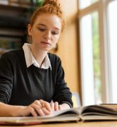 lovely-red-haired-teenage-girl-studying-min
